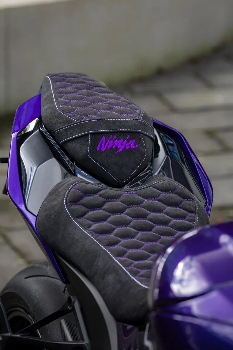 Schwarz-violette Motorradsitzbank mit Rautensteppung und violetten Nähten